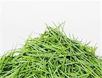 A pile of organic wheatgrass on a white background