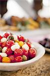 Organic prepared vegetables on a dish, laid out for a party.  Heirloom red and orange tomatoes and bocancini salad. A farm stand food stall.