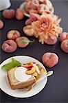 Fresh fruit and flowers. A slice of organic peach cake with a serving of creme fraiche and doughnut peaches.