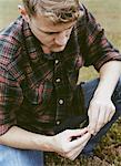 A cranberry farm in Massachusetts. Crops in the fields. A young man working on the land, harvesting the crop.