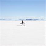 Boy riding bike on salt flats, during Speed Week