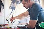 Mature male artist working on canvas in studio