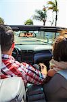 Young couple driving convertible, San Diego, California, USA