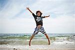 Informal portrait of jumping boy on beach at Falmouth, Massachusetts, USA