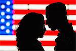 Silhouette of young couple in front of American flag