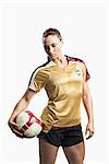 Studio shot of young female soccer player holding ball