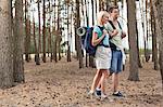 Full length of happy young couple hiking in forest