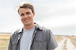 Portrait of handsome young man standing on field