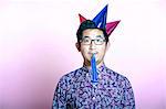 Young Geeky Asian Man wearing many party hats