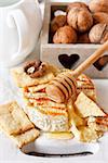 Baked camembert with honey and nuts served with crispy crackers close-up.