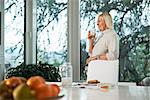 Portrait of senior caucasian woman drinking fresh milk for breakfast at home