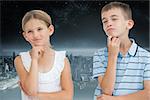 Thoughtful brother and sister posing together against balcony overlooking city