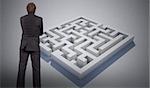 Thinking businessman against maze puzzle