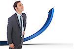 Cheerful businessman standing with hand on hip against blue arrow pointing up