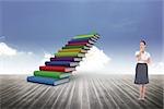 Pensive elegant businesswoman posing against book steps against sky