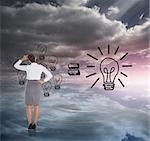 Businesswoman scratching her head against light bulbs graphic on colourful horizon