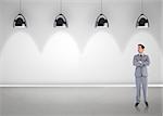 Serious businessman with arms crossed against grey room