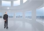 Rear view of mature businessman posing against bright white room with windows