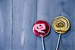 Photo of pink and yellow lollipops on wooden background
