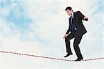 Stock image of businessman walking the tightrope