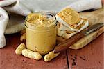 homemade peanut butter with whole nuts on a wooden table