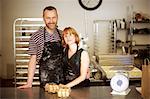 Portrait of baker couple behind kitchen counter