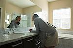 Woman pondering in front of mirror