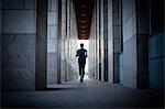 Young man running along urban sidewalk