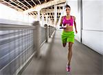 Blurred shot of young woman running on urban bridge