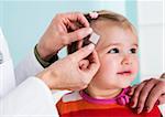 Doctor putting Bandage on Baby Girl's Head in Doctor's Office