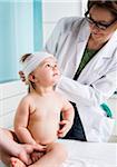 Doctor Putting Bandage on Baby Girl's Head in Doctor's Office