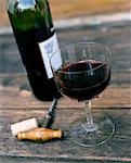 High angle view of red wine in glass and corkscrew