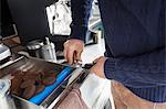 Midsection of man preparing coffee at mobile coffee shop