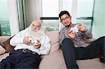 Portrait of grandson playing video game on sofa at home