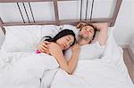 Multiethnic couple sleeping in bed