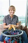 Smiling mid-adult man with laundry basket sitting on sofa at home