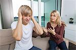 Woman trying to talk as man yells out aloud in living room at home