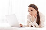 Young businesswoman using laptop in hotel room