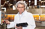 Man looking at tablet PC while working in bottling factory