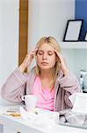 Young woman massaging head while suffering from cold