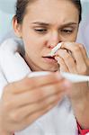 Close-up of worried woman taking her temperature