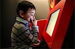 Boy playing with a computer at la Cité des Sciences, Paris France.