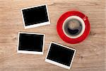 Cup of coffee and three photo frames on wooden table