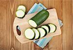 Zucchini on cutting board over wooden table background