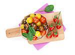 Colorful cherry tomatoes on cutting board. View from above. Isolated on white background