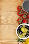 Red wine with olives, tomatoes and spices. Over wooden table background. View from above with copy space