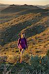 Young woman hiking outdoors on a trail at Phoenix Sonoran Preserve in Phoenix, Arizona.