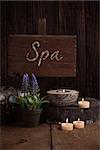 Spa and wellness setting with natural soap, candles and towel. Wooden dayspa nature setting