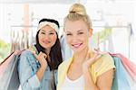 Portrait of two happy young women with shopping bags in the clothes store