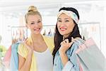 Portrait of two happy young women with shopping bags in the clothes store